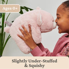 Child holding a pink plush toy with text indicating age suitability and product description.