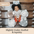 Child sitting among plush toys on a wooden floor with text indicating age suitability and product description.