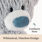 Plush bear with a blue corduroy nose on a white background