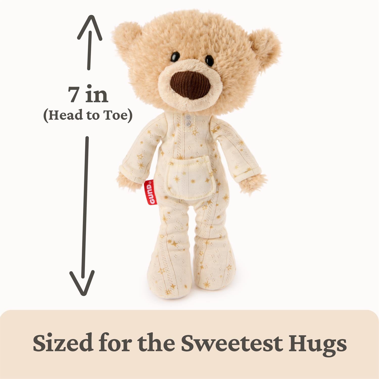 Stuffed teddy bear in pajamas with a measurement label on a white background