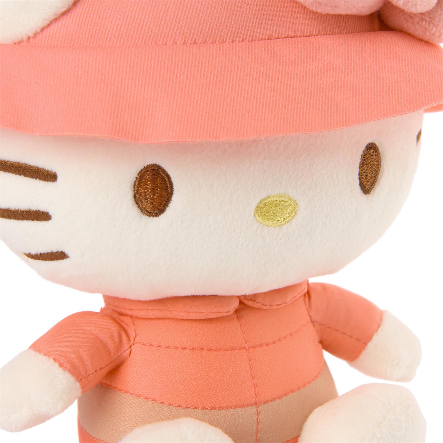 Plush toy resembling a cat character with a pink outfit on a white background