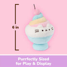 A pastel plush toy shaped like a dessert cup with a cat face, shown on a pink background with a height marker reading 6 in and text at the bottom that says 'Purrfectly Sized for Play & Display'.