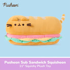 Pusheen Sub Sandwich Squisheen plush toy shaped like a sub sandwich, featuring Pusheen's face on the bread, pink and green ruffles, and a striped tail, shown on a light blue background with a purple text banner at the bottom.