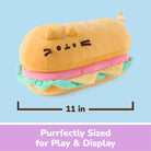 A plush sandwich-shaped pillow in yellow, pink, and mint green with a cat face, shown on a light blue background with a measurement label of 11 in and a purple banner reading 'Purrfectly Sized for Play & Display'.