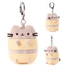 Plush keychain of a cartoon cat character in a yellow outfit with a white background