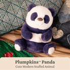 A plush panda toy sitting on a wooden surface with decorative pillows around it. The text overlay at the bottom reads 'Pumpkins™ Panda Cute Modern Stuffed Animal'.
