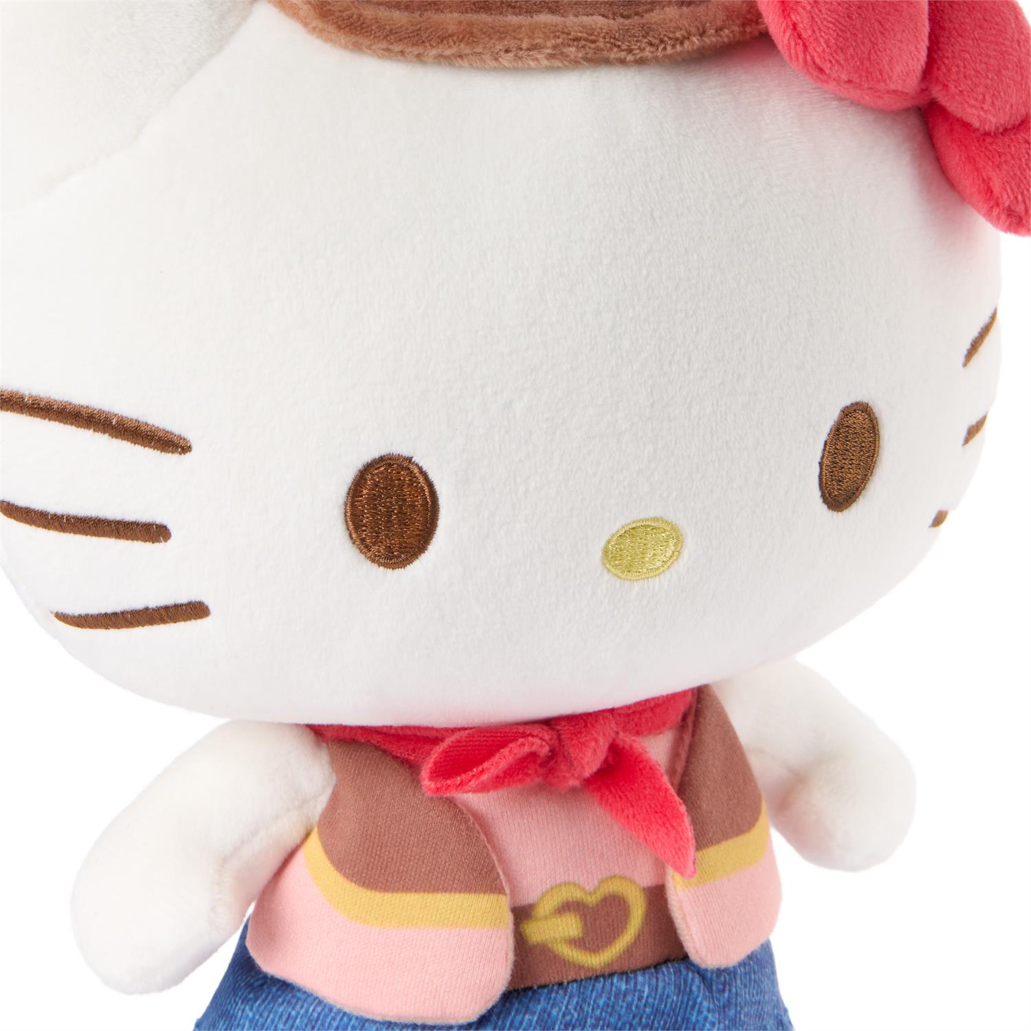 Plush toy resembling a cat character with a red bow and blue skirt on a white background