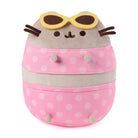 Plush toy resembling a cat with polka dot pink bag and sunglasses on a white background