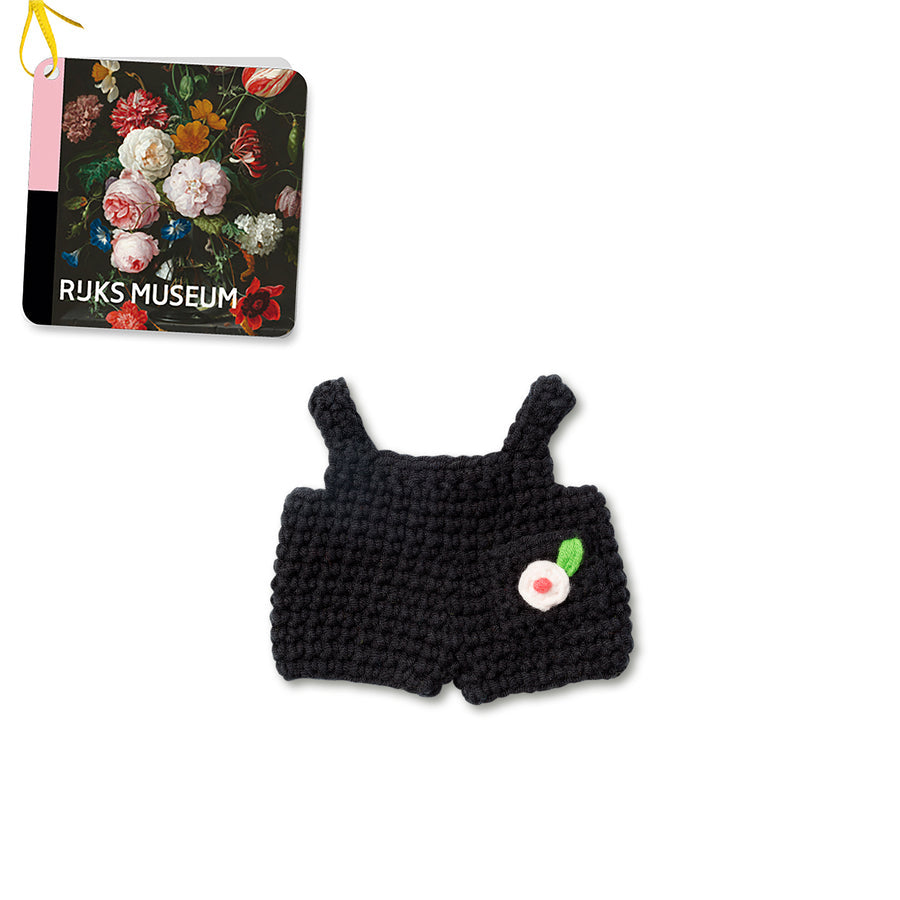 Knitted black romper with white flower embellishment.