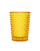 Yellow glass tumbler with a textured rim on a white background