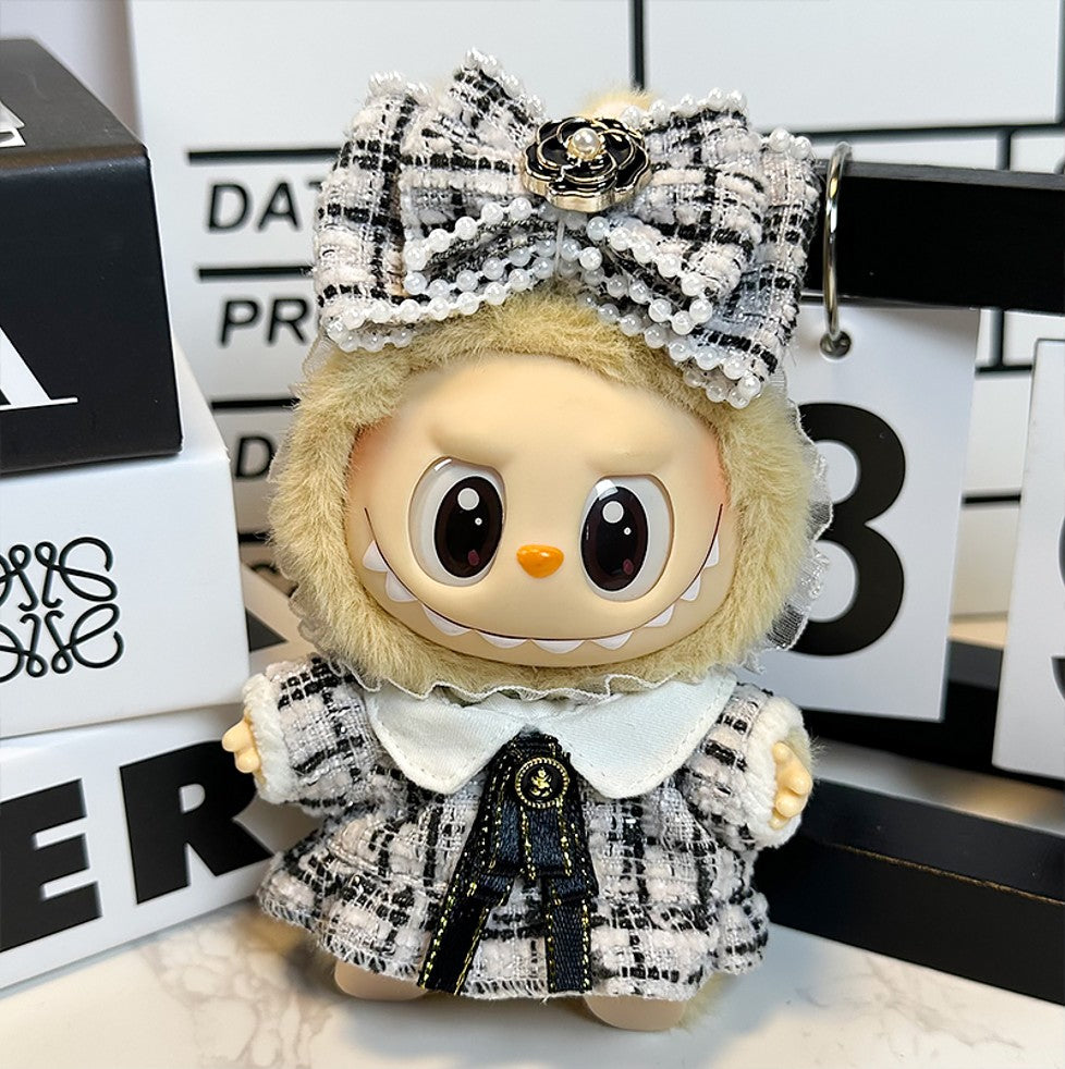 A stuffed doll wearing a tweed dress and bow.
