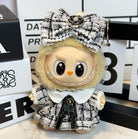 A stuffed doll wearing a tweed dress and bow.
