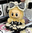 A yellow doll with a black and white bow and a white and black dress.