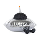 Silver plush UFO toy with black glittery dome and orange-tipped antenna by Jellycat, featuring smiling face and dangling feet, front view