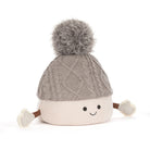 A plush baby hat with a gray cable-knit top, a cream ribbed bottom, a gray pom-pom, and small fabric hands and feet, shown on a white background.