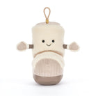 A plush baby boot toy in cream and beige with a smiling face, small fabric hands, and a tan hanging loop at the top, photographed on a clean white background.