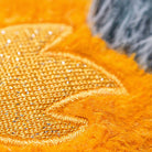 Orange plush space comet toy by Jellycat with golden sequined embroidery and fuzzy texture, close-up side view