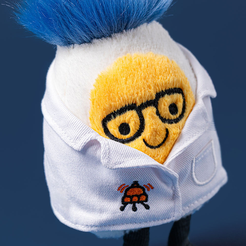 Plush boiled egg toy in white lab coat with black glasses, blue fuzzy hair, and embroidered beaker patch, front view