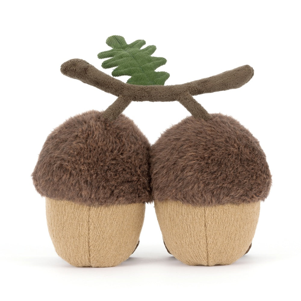 Stuffed acorn toy with a branch on a white background