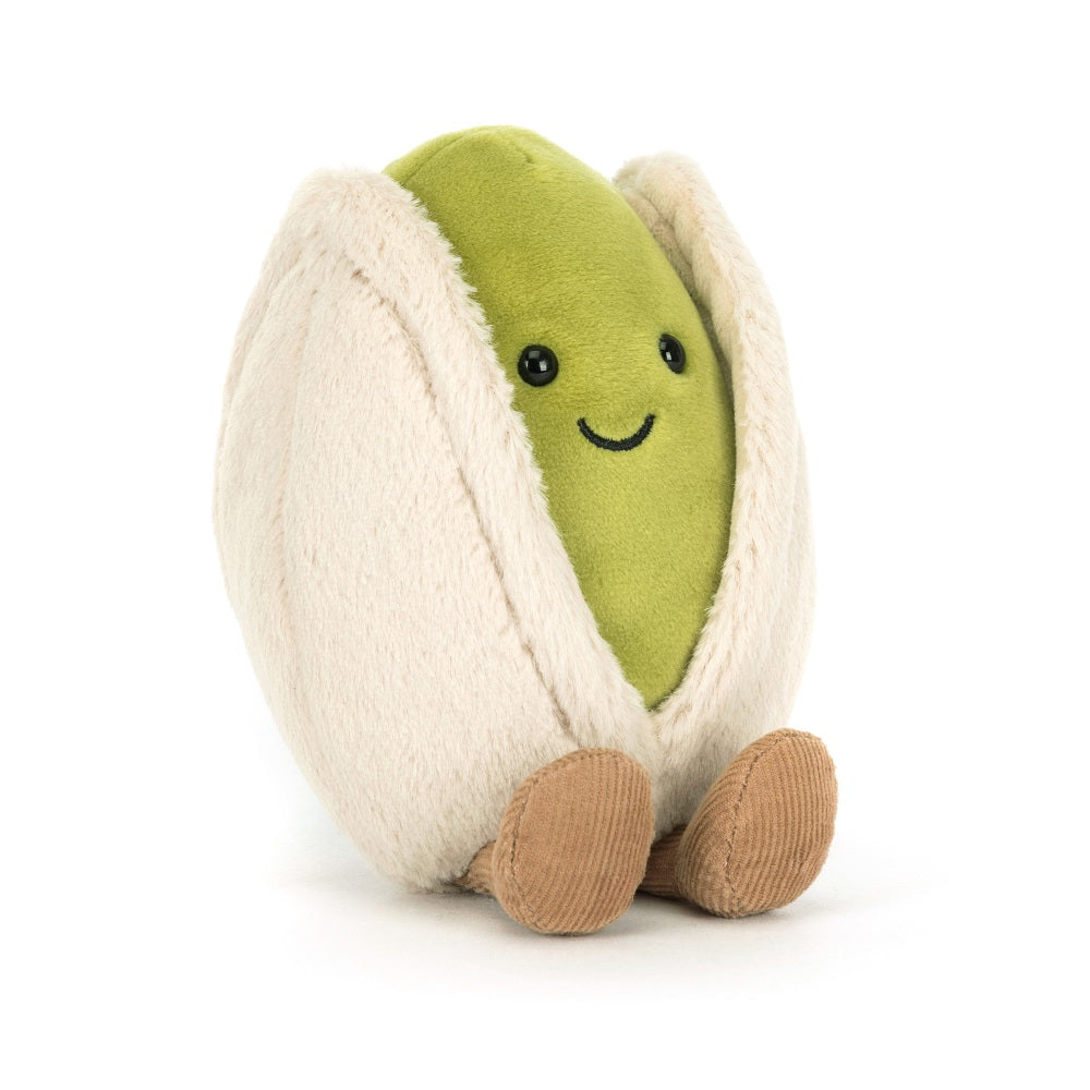 A stuffed pistachio nut toy sitting upright.
