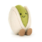 A stuffed pistachio nut toy sitting upright.
