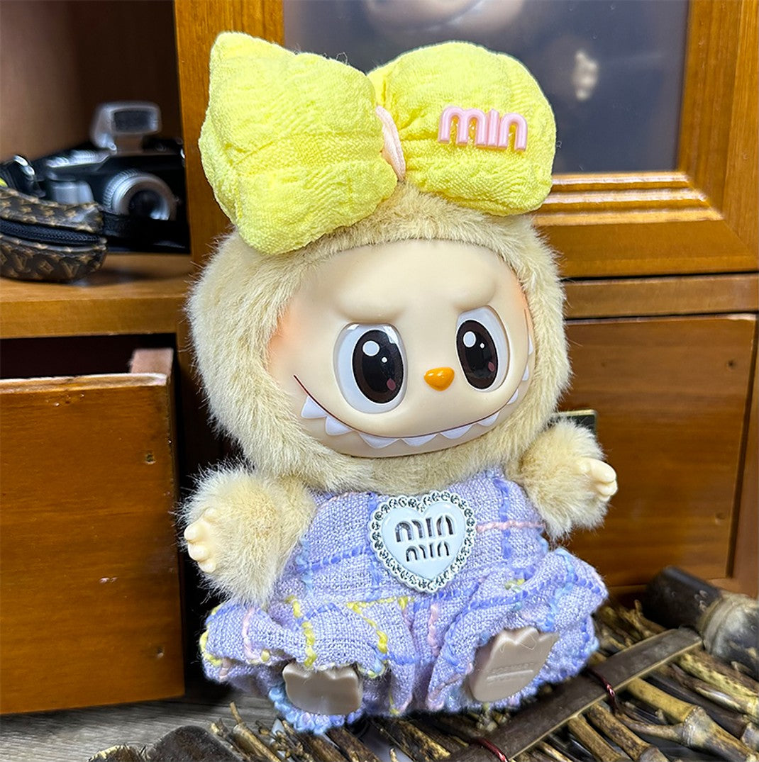 Stuffed toy with yellow bow and patterned dress.
