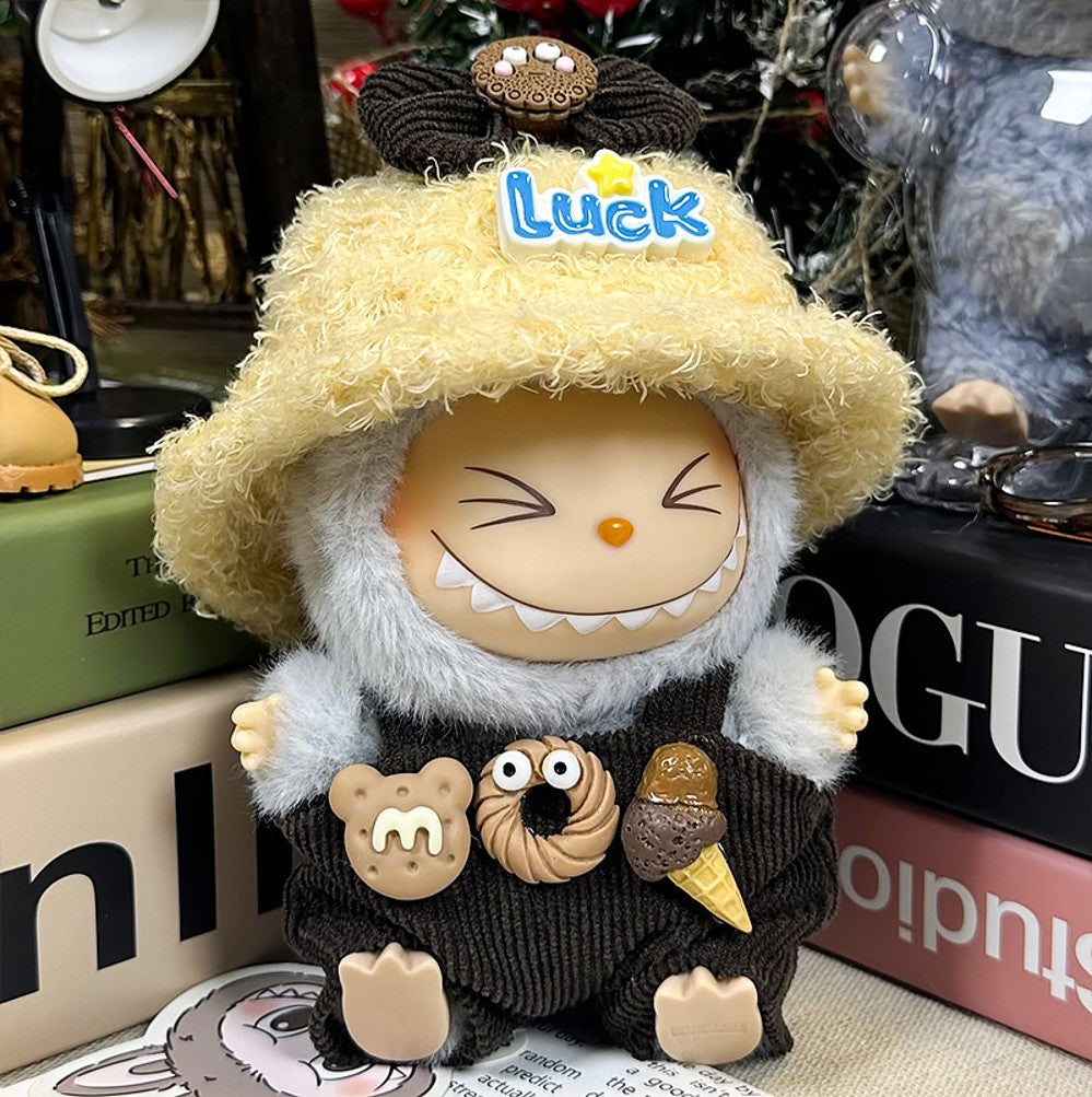 Close-up of a toy figure with a shaggy hat, wearing overalls with food-shaped decorations.