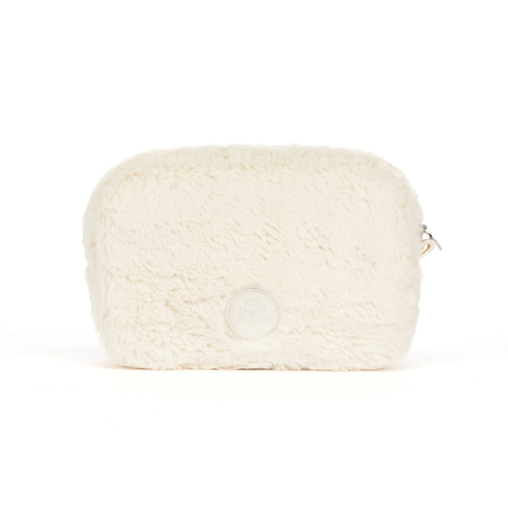 An off-white faux fur cosmetic pouch with a small silver zipper pull and a circular embossed logo on the front, set against a plain white background.