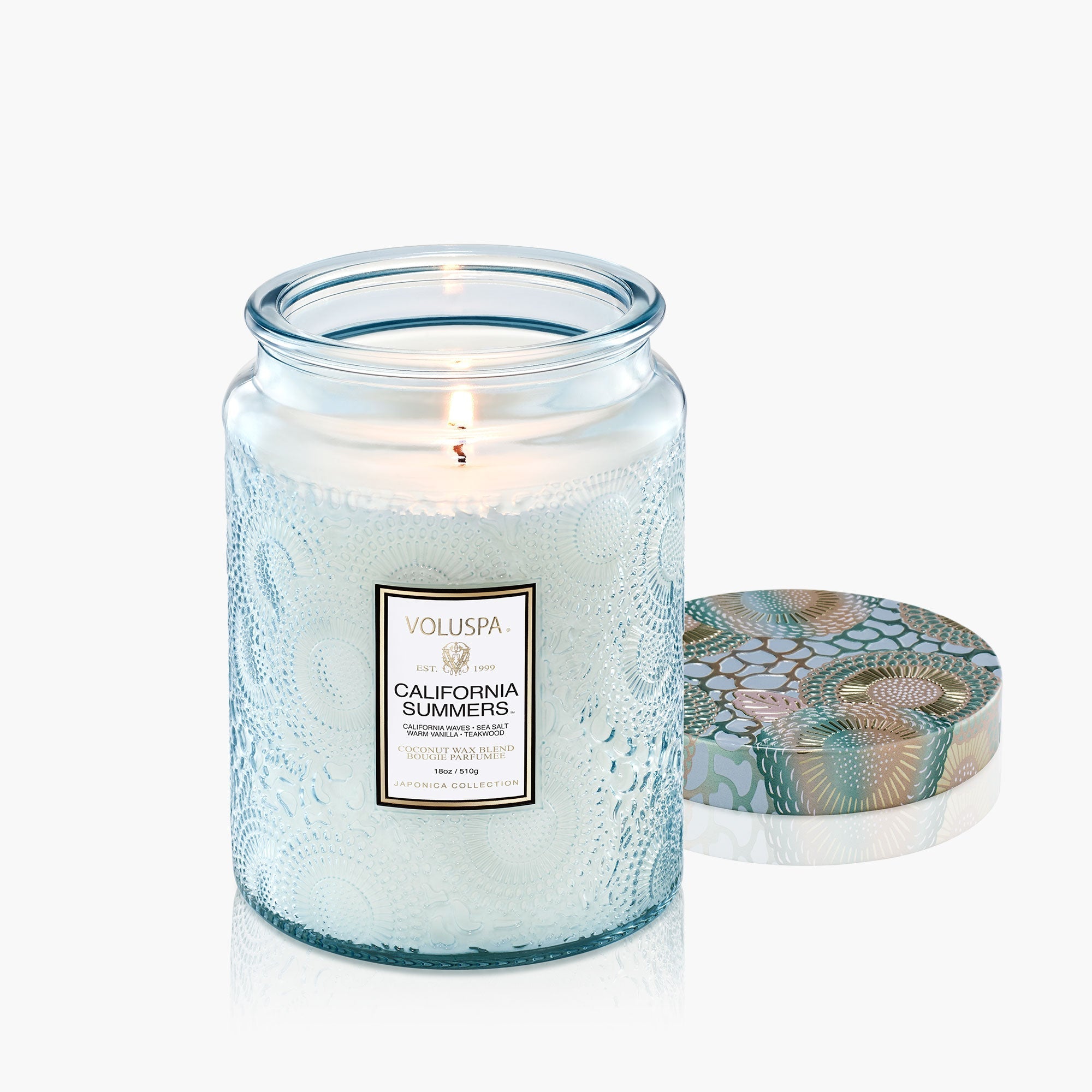 Voluspa candle in a textured jar with decorative lid on a white background