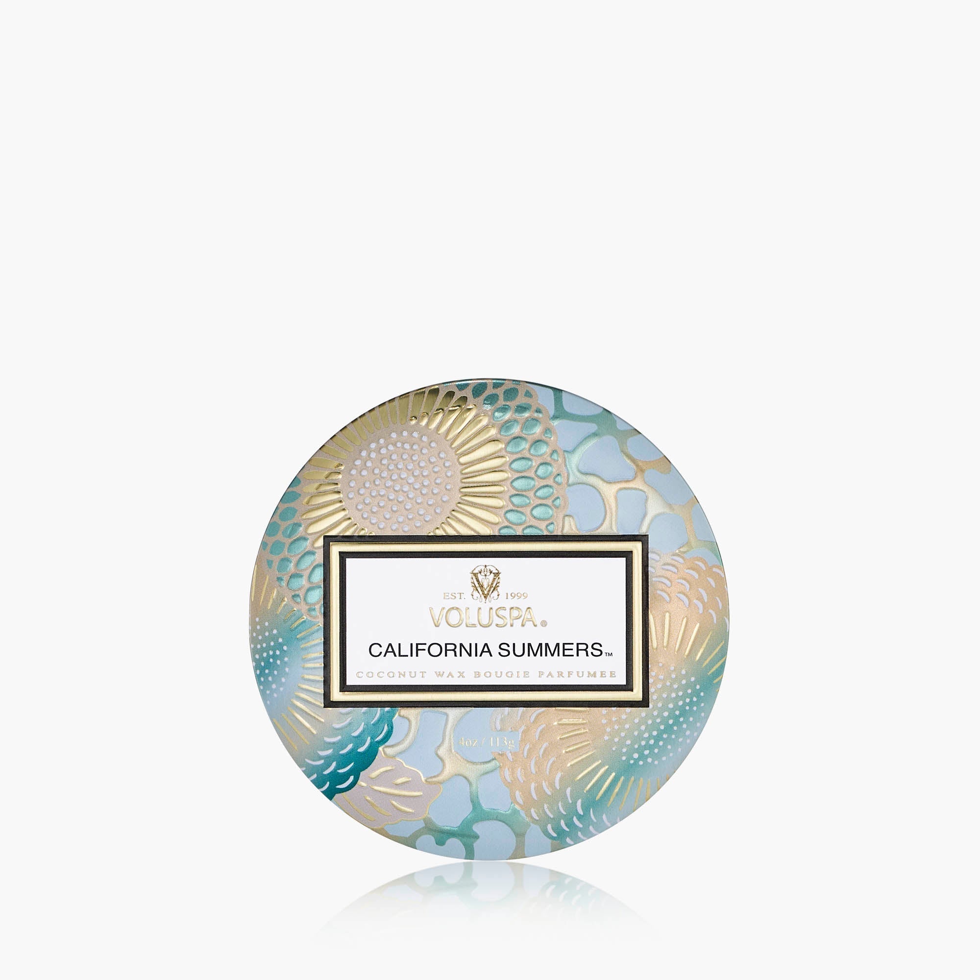 Round Voluspa candle packaging with decorative design on a white background