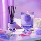 Decorative candles and diffuser on a table with a soft, blurred background
