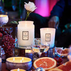 Candles with a rose and fruit on a table with a blurred background