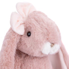 Close-up of a pink plush bunny with a white flower on a white background