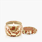 Candle in a decorative container with a pattern on a white background
