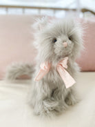 Gray plush cat with pink bow tie.