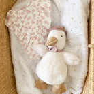 Top, toy goose, blanket in wicker basket.