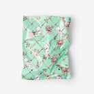 Green patterned fabric with cherub designs on a white background