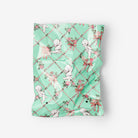 Green patterned fabric with cherub designs on a white background