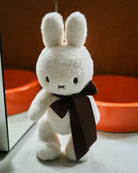 White bunny plush with brown ribbon.