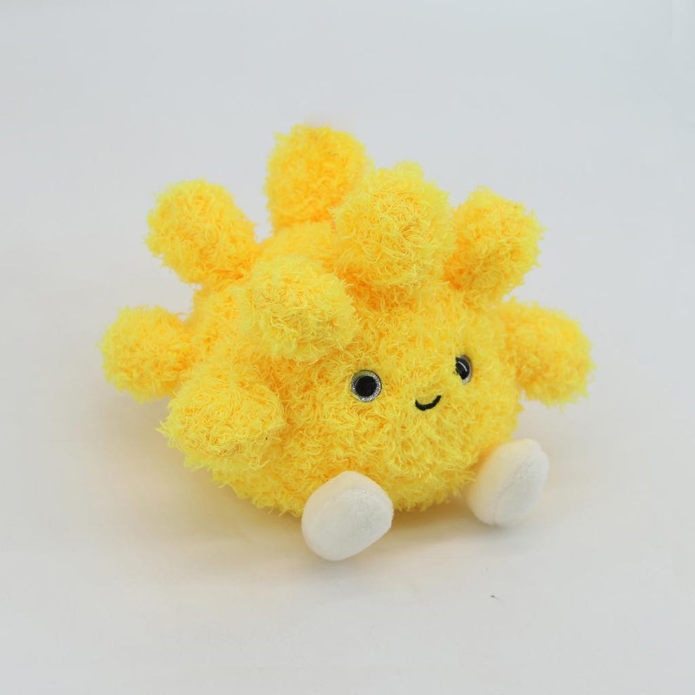 Yellow plush sun toy with a smiling face on a white background