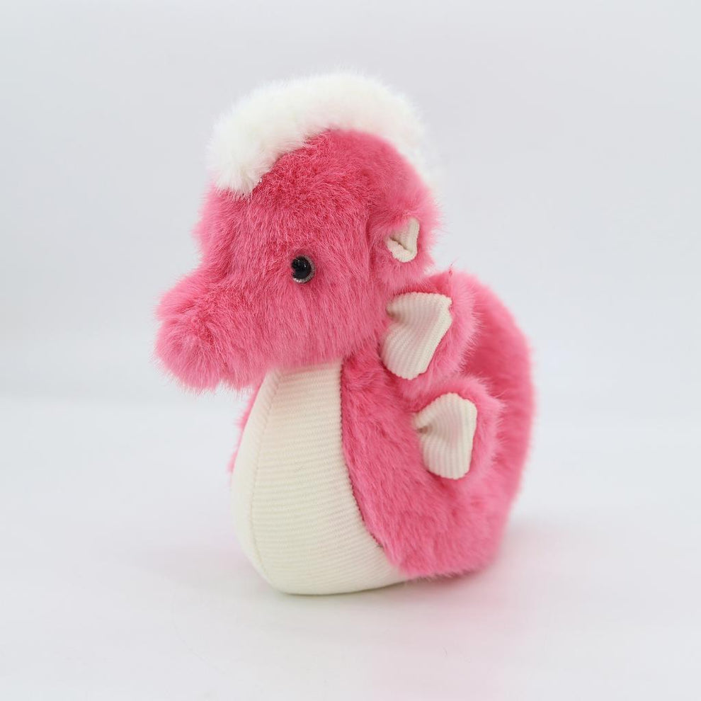 Pink and white plush dragon toy on a light gray background