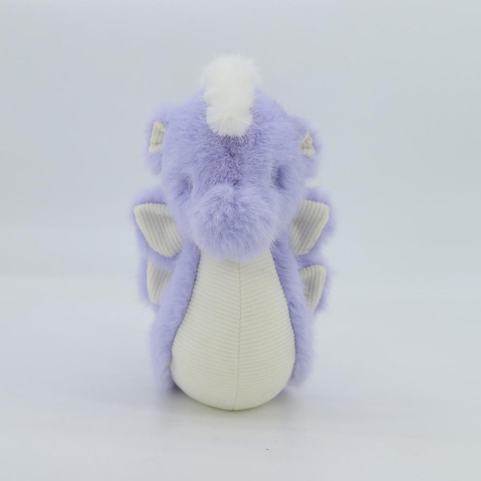 Plush toy dragon with purple fur and white accents on a light gray background