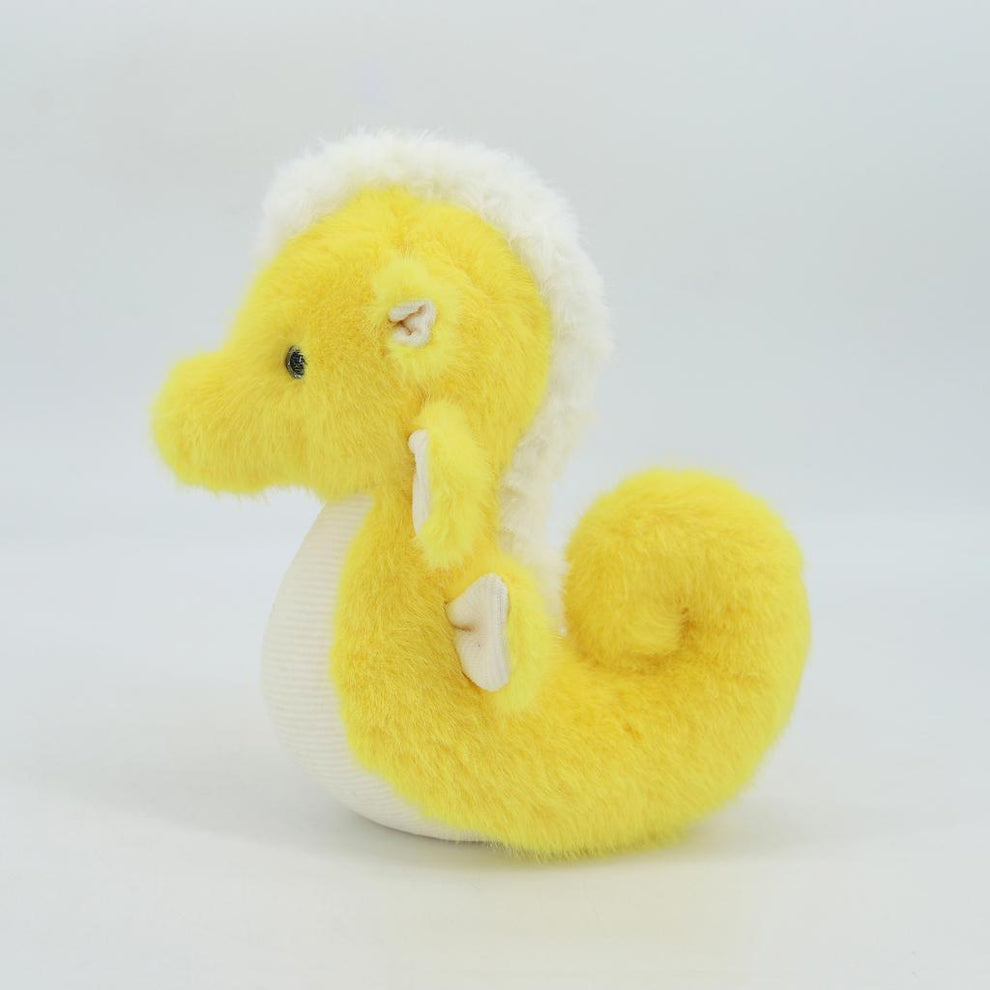 Yellow plush seahorse toy on a white background