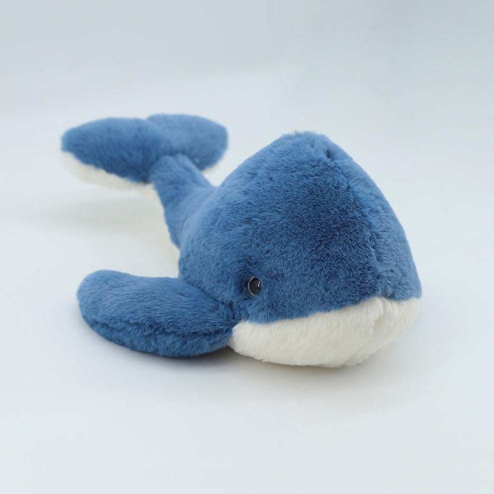 Blue plush whale toy on a white background