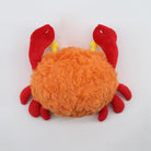 Plush crab toy with orange body and red legs on a white background