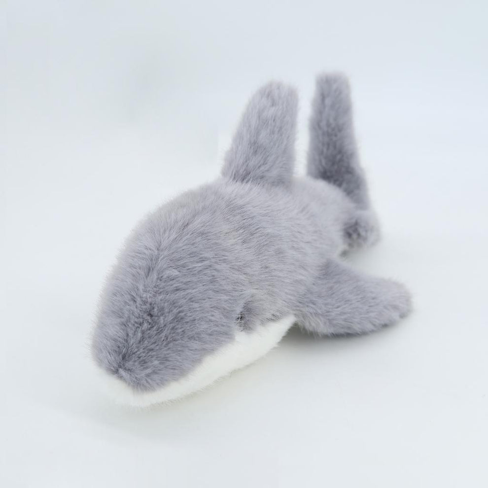 Gray plush toy resembling a rabbit on a light gray background