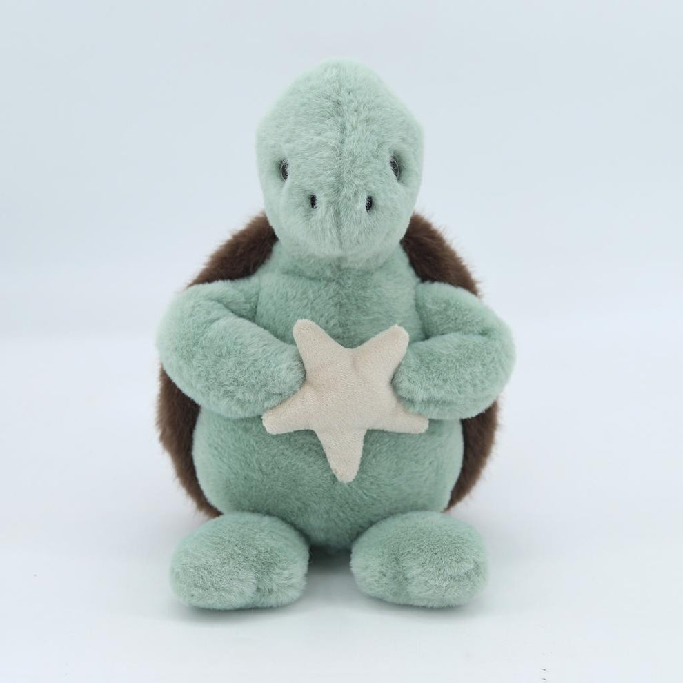 Plush turtle toy with a star on a white background