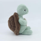 Plush turtle toy with a brown shell on a white background