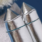 Shiny silver rocket boots with teal stitching on Jellycat Munro Scottie Dog, close-up side view