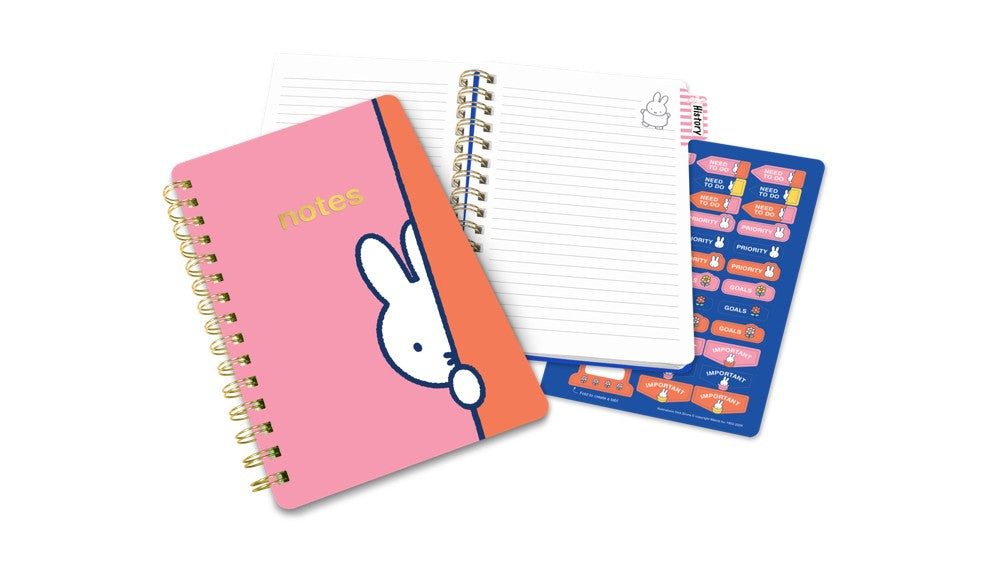 Pink notebook with a cartoon character on the cover and a blue planner on a white background